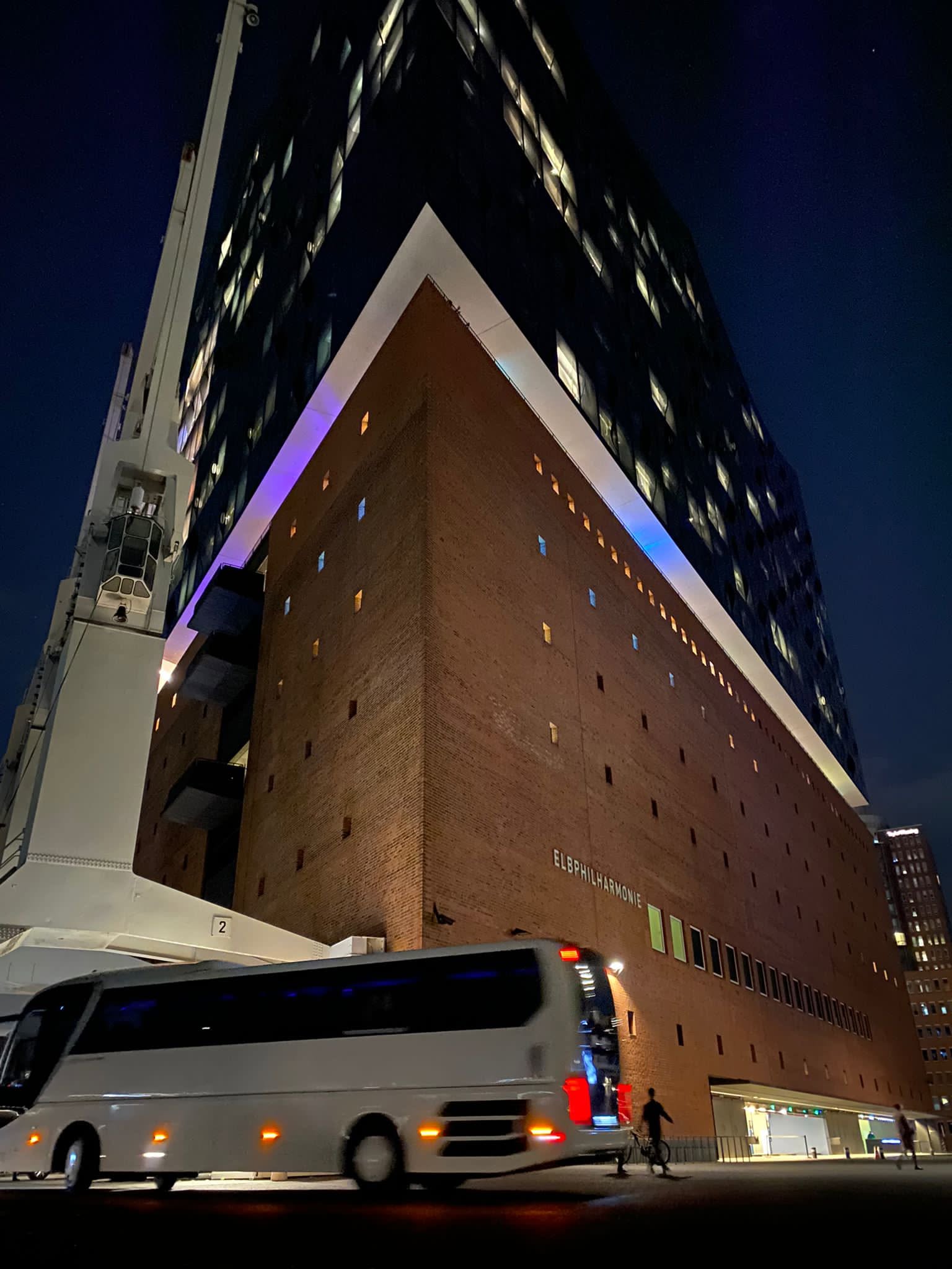 Reisebus vor der Elbphilharmonie Hamburg bei Nacht