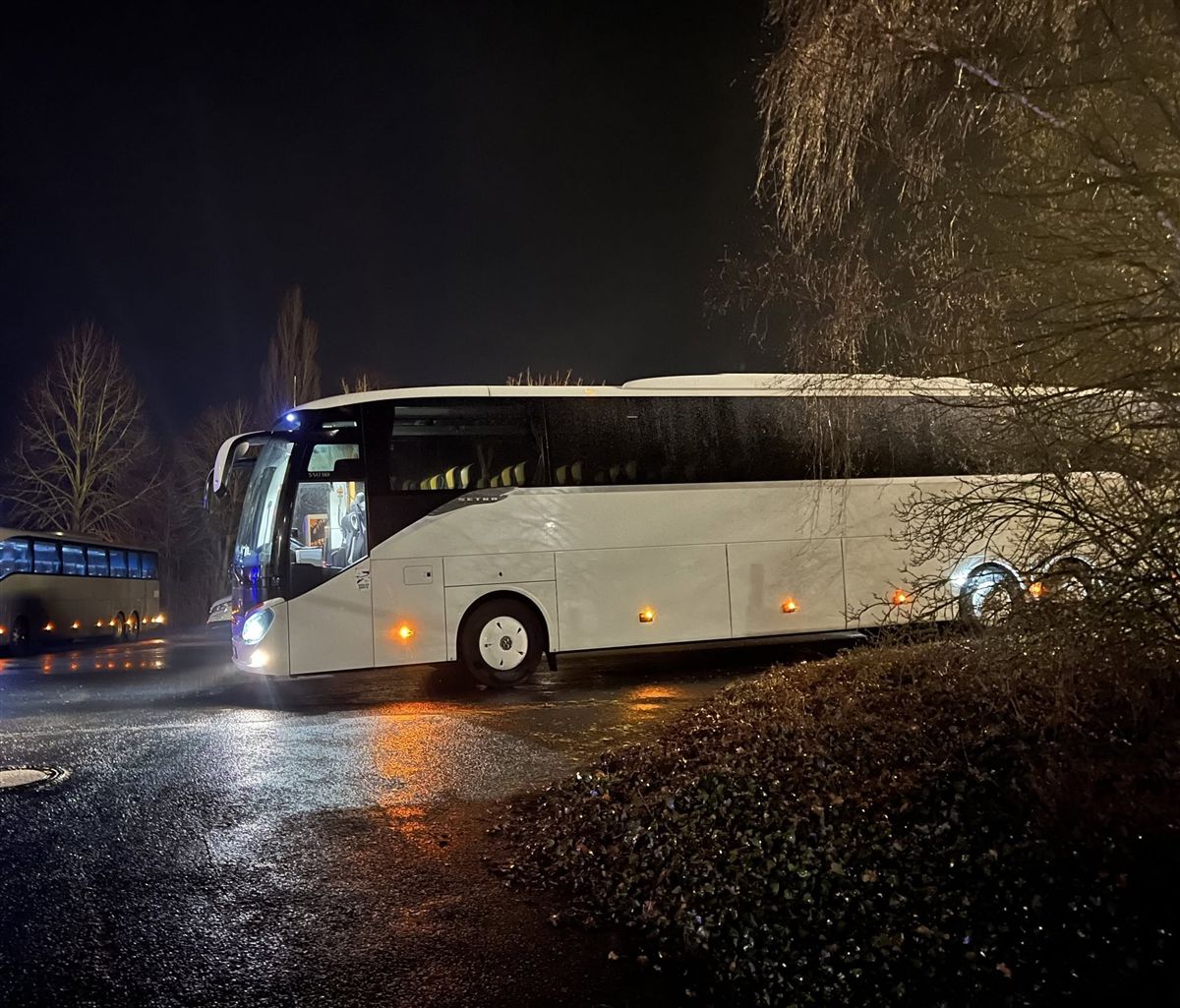 Two coaches at night on a parking area