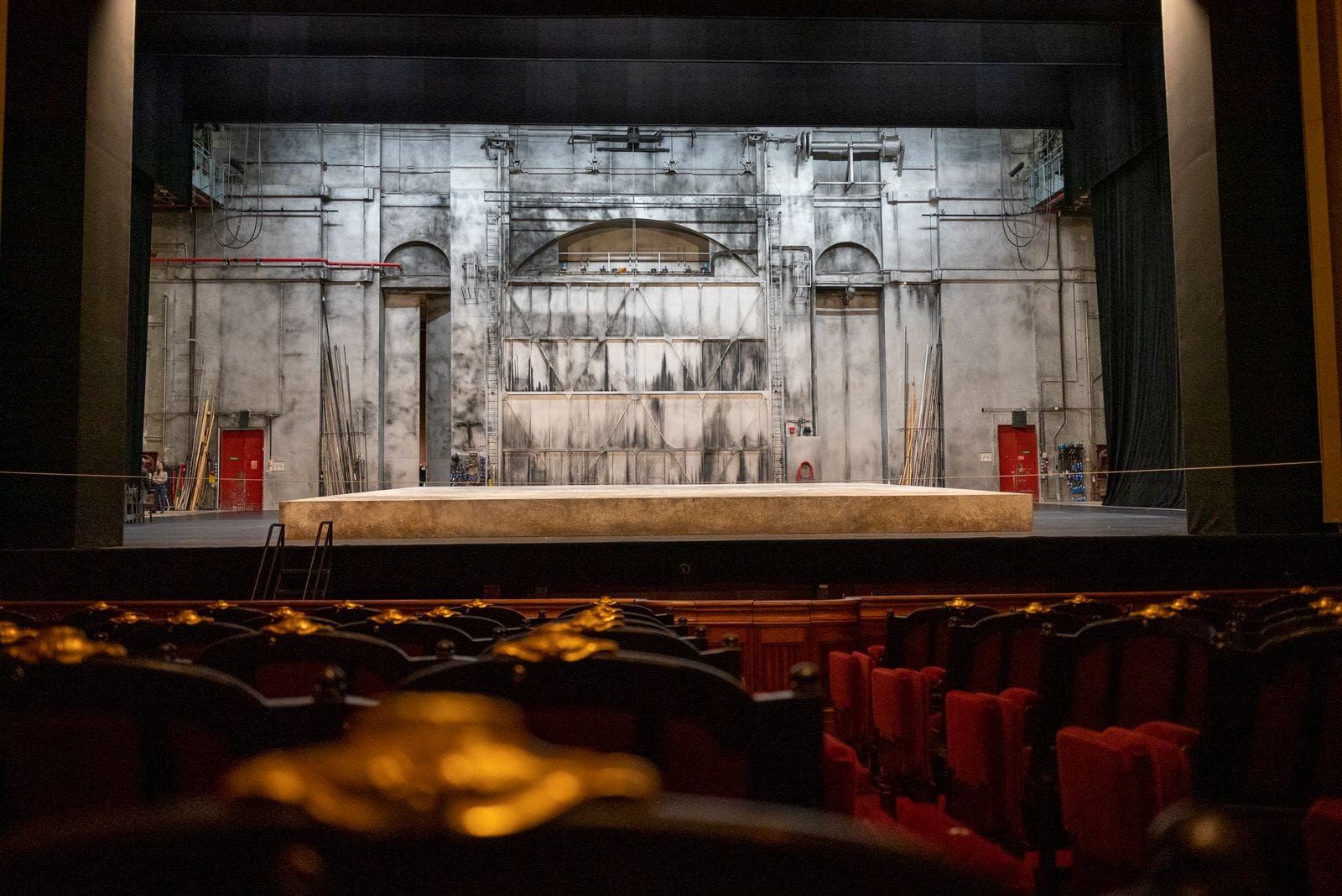 Leere Theaterbühne mit Bühnenbild und roten Sitzreihen